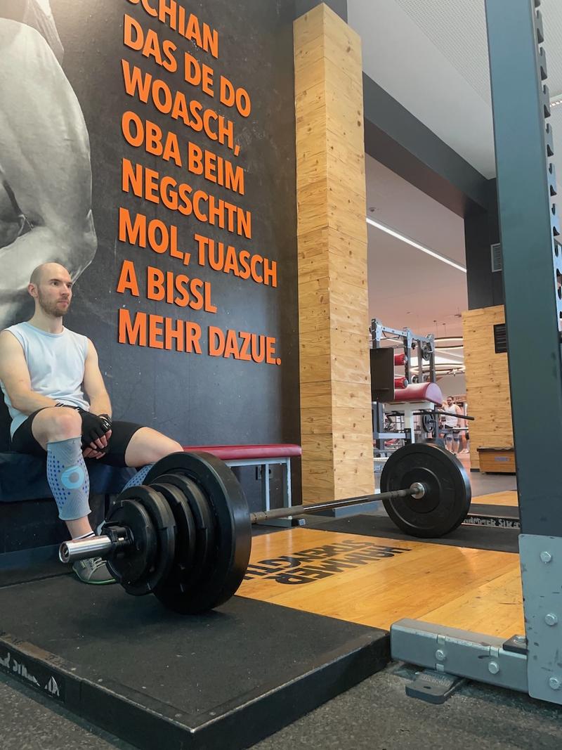 Me sitting by a loaded barbell in the ground